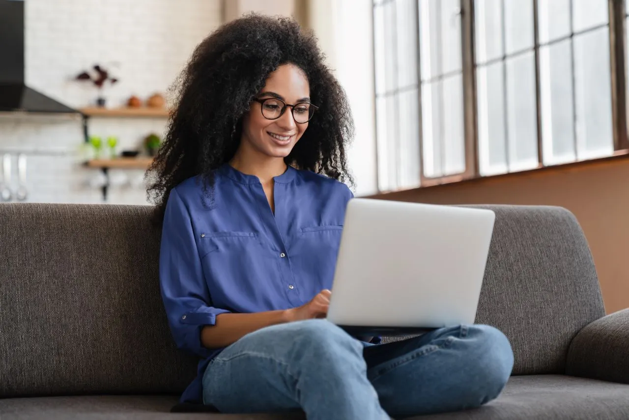 O que é o e-CPF e como ele funciona? | Foto de uma mulher negra trabalhando no notebook em casa | Certificação Digital | Blog da Certisign