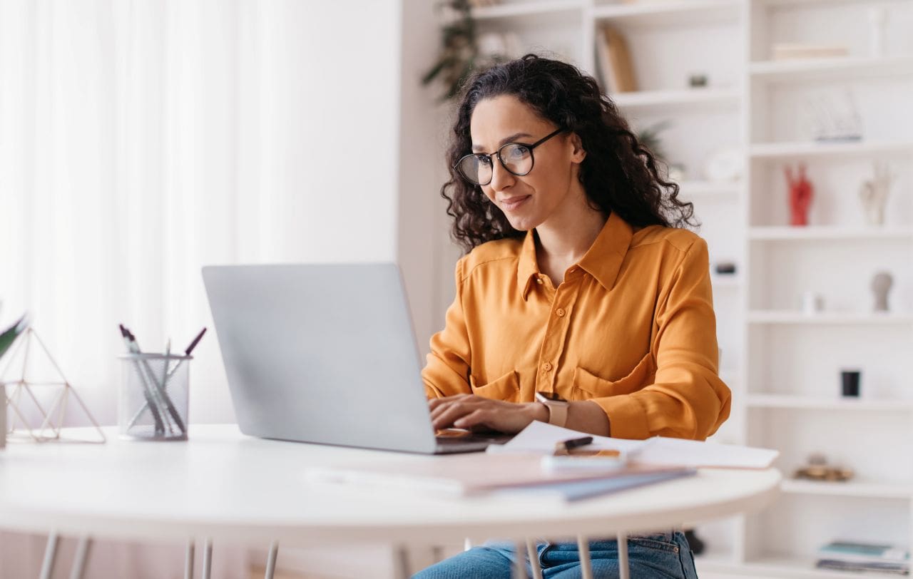 Vantagens do certificado digital na nuvem | Foto de uma mulher feliz no notebook | Certificação Digital | Blog da Certisign