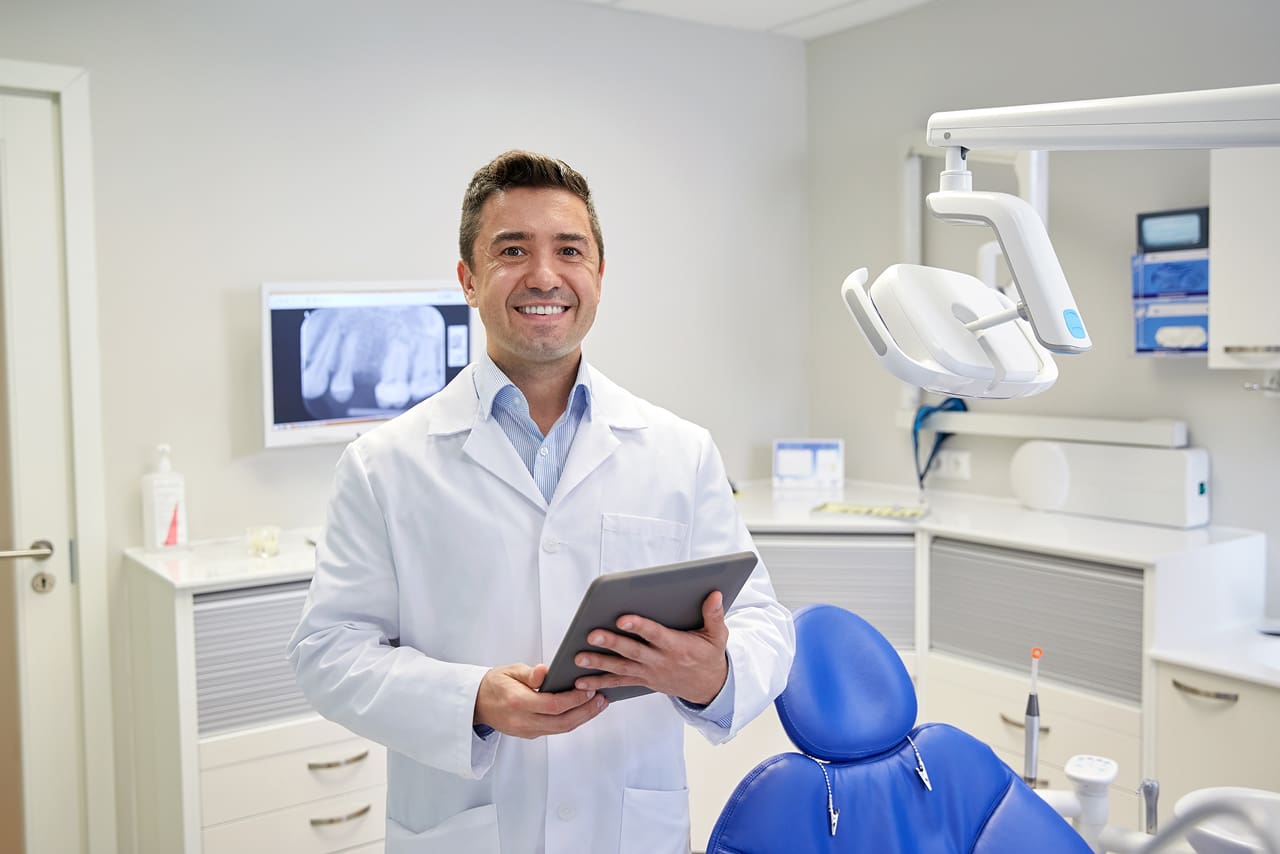 O que é a assinatura digital para dentistas? | Foto de um dentista assinando receita médica digital na clínica odontológica | Profissionais da Saúde | Blog da Certisign